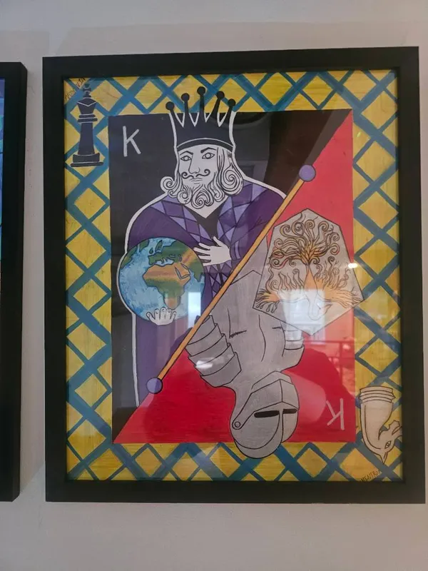 A playing card king split between light and shadow, holding a globe and a flaming scepter